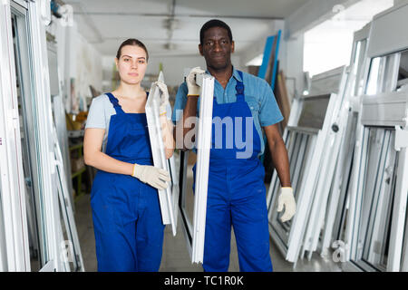 Two masters are working with window frame in the window workshop. Stock Photo
