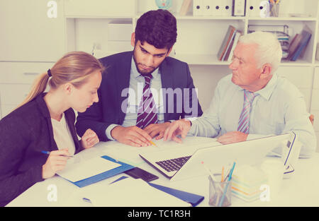 Managers are writing financial reports in the office. Stock Photo