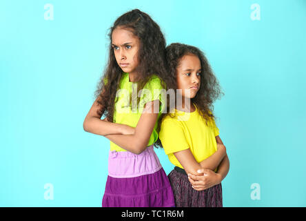 Offended African-American girls on color background Stock Photo