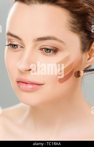 attractive woman with eye shadow brown palette on face isolated on grey Stock Photo