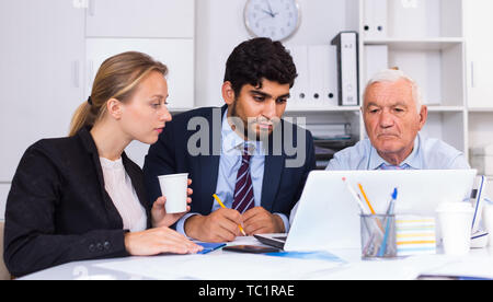 Managers are writing financial reports in the office. Stock Photo