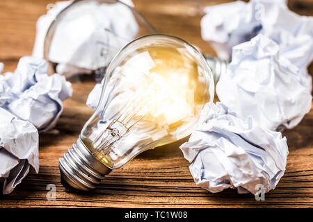 great idea concept with crumpled office paper and light bulb standing on table Stock Photo