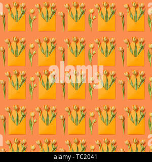 Decorative pattern with gift envelopes of tulips flowers on an orange. Stock Photo