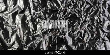 Black dark silver crumpled plastic material texture background Stock Photo