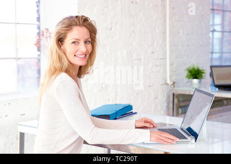 Close-up portrait of executive middle aged businesswoman sitting at office desk and analyzing financial data. Stock Photo