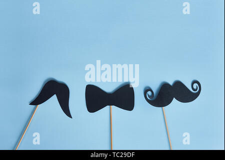 Black mustaches on blue paper background. Happy fathers day greeting card and place for text. Hipsters objects flat lay Stock Photo