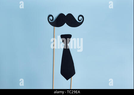 happy father's day. decorative man mustache and bow-tie on a light blue wooden background. top view Stock Photo