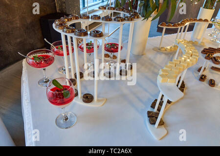 Candy bar on the white table with a different kunds of sweets and other desserts beautiffully served on the wedding Stock Photo