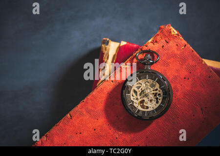 Pocket watch and old book on cement floor. Top view and copy space for text. Concept of time and education. Stock Photo