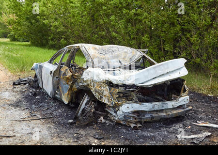 Fully burned car after collision with truck in summer, accident background Stock Photo