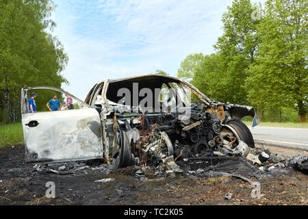 Fully burned car after collision with truck in summer, accident background Stock Photo