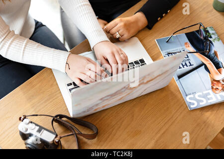 Top view of Bloggers Publishing Using Laptop At Cafe Stock Photo
