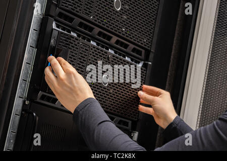 Close-up of Hands Of IT Consultant Installing Servers In Rack at Datacenter Stock Photo