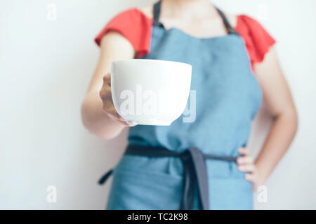 Closeup of female hand holding a big white mug, mock up for text. Stock Photo