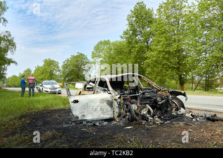 Fully burned car after collision with truck in summer in May 23, 2019, in Latvia, next to Pinki, accident background Stock Photo