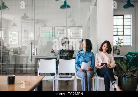 Two job applicants waiting in an office to be interviewed Stock Photo