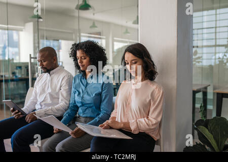Applicants waiting outside of a manager's office before being interviewed Stock Photo