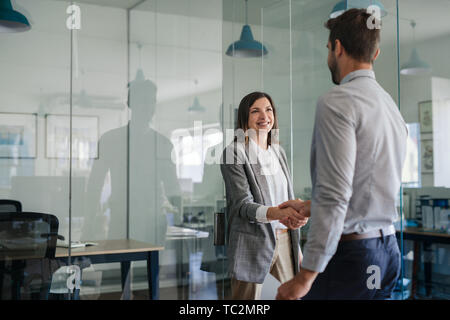 Manager smiling while welcoming a new office employee Stock Photo
