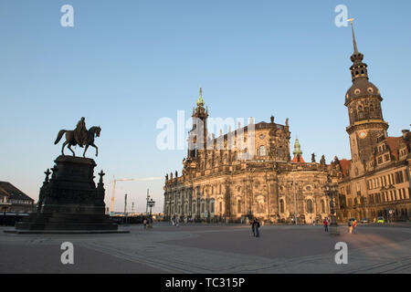 Dresden, Germany. 04th June, 2019. Tourists stand in the light of the setting sun on the Theaterplatz in front of the Catholic Hofkirche (M) and the Hausmannsturm. On the left is a equestrian statue of King Johann of Saxony. Credit: Sebastian Kahnert/dpa-Zentralbild/ZB/dpa/Alamy Live News Stock Photo