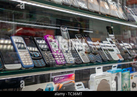 April 28, 2019. Athens, Greece. Phones new and retro through shop's showcase. Telephones evolution from keypad to touchpad on store's shelves. Stock Photo