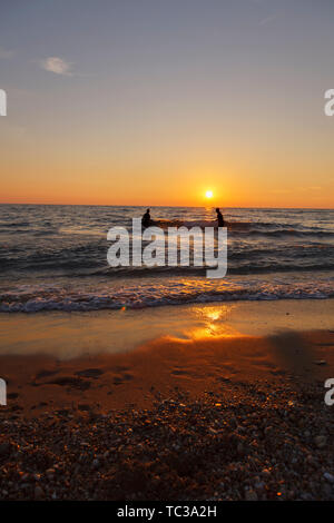 Happy friends at sunset sea beach. A family enjoy a holiday on the beach Stock Photo
