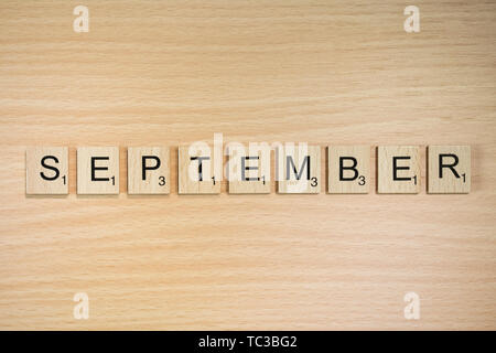 The word September, spelt out using wooden tiles on a wood effect ...