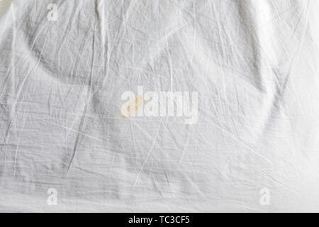 Dirty and creased sheet on bed, disgusting stain Stock Photo