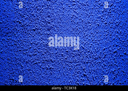 Brightly lit surface covered with bright blue plaster. Trend color Stock Photo
