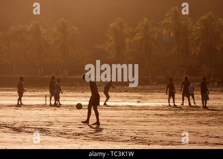 Young people playing football on the beach, evening light, Playa Samara, Samara, peninsula Nicoya, province Guanacaste, Costa Rica Stock Photo