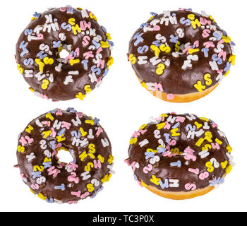 Four sweet baked donuts sprinkled with colorful capital letters. Isolated on white background. Round fried fat doughnuts. Chocolate topping. Junk food. Stock Photo