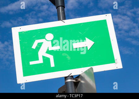 Emergency exit sign fixed on street lamp pole Stock Photo