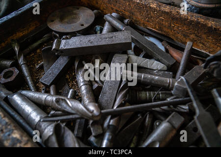 Bunch of old tools in a wooden box on a workshop shelf Stock Photo