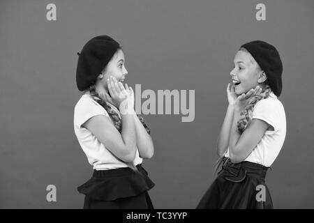 Surprised girls wear formal uniform red background. International exchange school program. Education abroad. Apply form enter international school. French language school. School fashion concept. Stock Photo