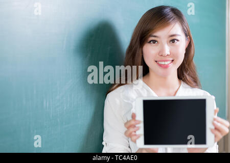 Asian beautiful woman speaking in front of blackboard with micro Stock Photo