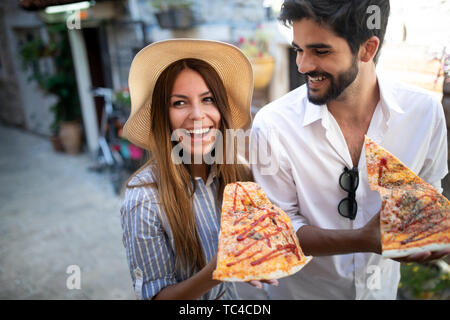 Couple eating pizza while traveling on vacation Stock Photo