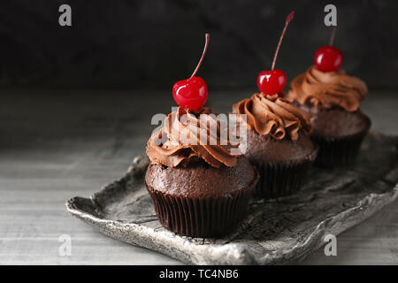 Tray with tasty chocolate cupcakes on grey background Stock Photo