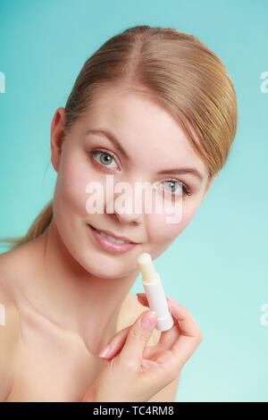 Female putting applying lip balm moisturizing balsam. Girl taking care of lips. Skincare. Stock Photo