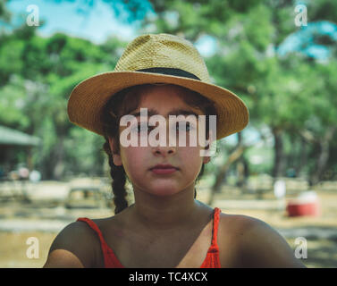 Portrait of a little girl wearing a hat outdoors. Young caucasian girl in summer time. Stock Photo