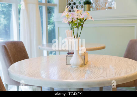 modern restaurant interior with windows and flowers. cafe room illuminated by sunlight Stock Photo