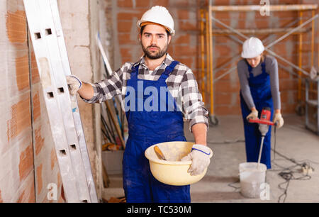 Portrait of builder in process of finishing work in cottage Stock Photo