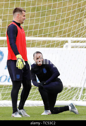 England's Tom Heaton (left) and Raheem Sterling during the training session at St George's Park, Burton. Stock Photo