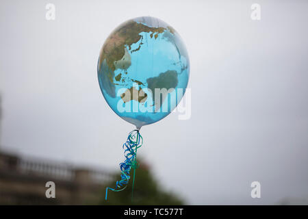 An earth shaped balloon floating on a string. Climate and environment concept Stock Photo