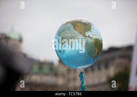 An earth shaped balloon floating on a string. Climate and environment concept Stock Photo