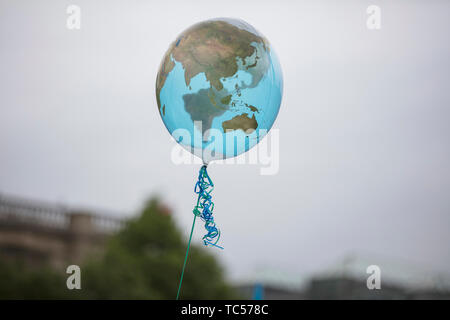 An earth shaped balloon floating on a string. Climate and environment concept Stock Photo