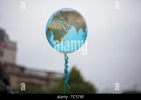 An earth shaped balloon floating on a string. Climate and environment concept Stock Photo