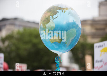 An earth shaped balloon floating on a string. Climate and environment concept Stock Photo