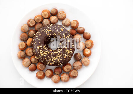 delicious donuts and hazelnuts on a plate Stock Photo