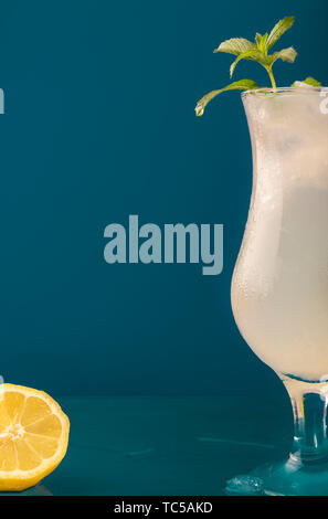 Lemonade glass with ice and mint leaves. Water droplets dripping on the glass surface. Cold drink with lemon slice and ice Stock Photo