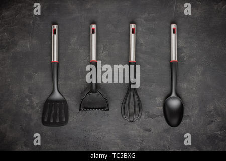Modern Black Plastic Kitchen Utensils on Dark Background Stock Photo