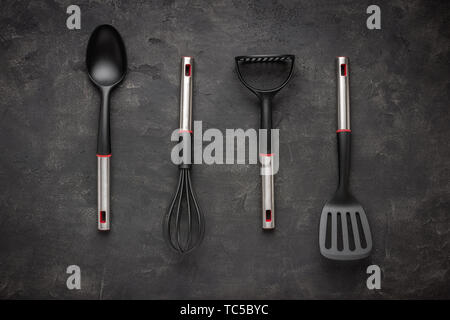 Modern Black Plastic Kitchen Utensils on Dark Background Stock Photo
